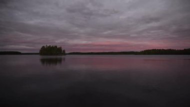 Finlandiya ormanlarında bulutlu bir akşamda göl