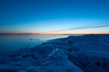 Finlandiya 'da kışın Bothnia Körfezi' nin donmuş kıyıları ön planda buzla kaplıdır.