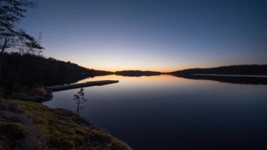 Finlandiya 'daki Kolovesi NP' de yaz gecesi sakin bir gölün dönüşümlü zaman çizelgesi