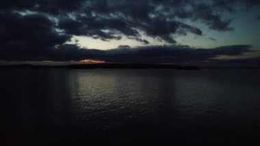 Finlandiya 'da Nasijarvi Gölü üzerinde alacakaranlıkta yükselen uçuş ufukta ormanlarla