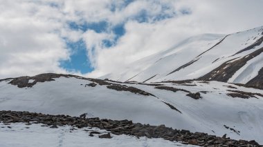 Svalbard 'da izleri olan karlı bir dağın yamaçları.