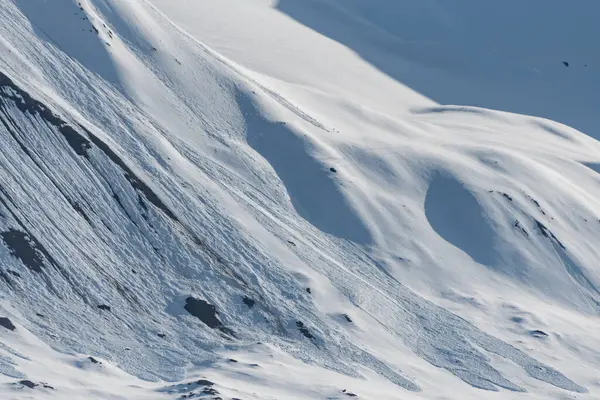 Kuzey Kutbu Svalbard 'da karlı bir dağ yamacında çığ izleri var.