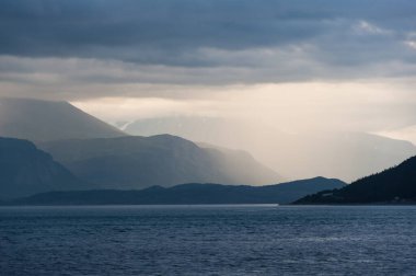 Kuzey Norveç 'te bir fiyort üzerindeki puslu dağ manzarası
