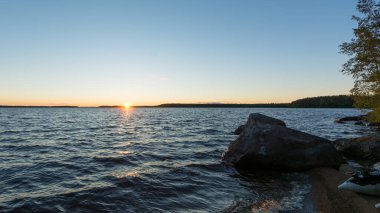 Finlandiya 'da yaz aylarında gölün arkasında gün batımı