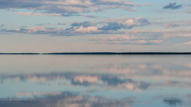 Finlandiya 'daki Lokka rezervuarının yüzeyindeki uzak ormanların yansıması.