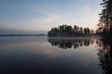 Finlandiya ormanlarında bahar gecesi sakin ve sakin bir göl.
