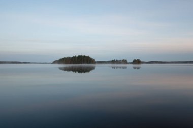 Finlandiya ormanlarında bahar gecesi sakin ve sakin bir göl.