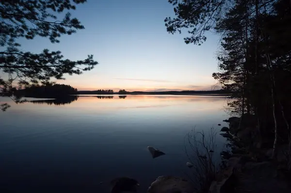 Finlandiya ormanlarında bahar gecesi sakin ve sakin bir göl.
