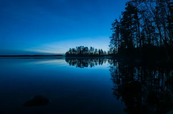 Finlandiya ormanlarında bahar gecesi sakin ve sakin bir göl.