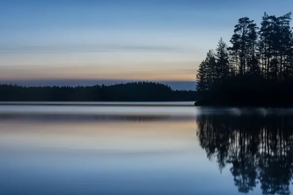 Finlandiya ormanlarında bahar gecesi sakin ve sakin bir göl.