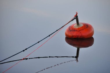 A lonely, red buoy in calm sea in summer in Finland clipart