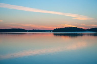 Yaz başında, Finlandiya 'da sakin bir gölün kenarında, sudan yükselen sisli bir havada.