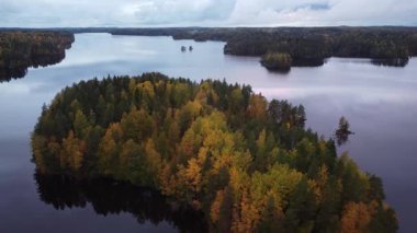 Finlandiya 'da göl kenarında sonbahar ormanları olan bir adanın klibi