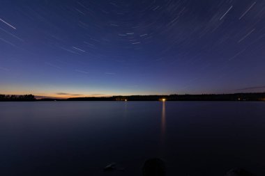 Yazın başında Finlandiya 'da göl kenarında gökyüzünde yıldız