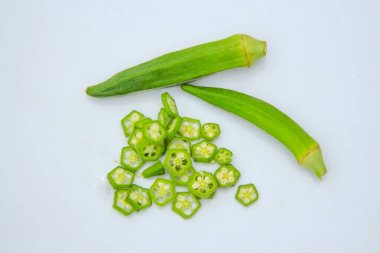 Beyaz arka planda izole edilmiş taze bamyanın yakın plan görüntüsü. Taze yeşil bamya sebzesi beyaz arka planda izole edilmiş. Beyaz arka planda bamyalar. Beyaz arka planda bamya ya da kadın parmağı sebzesi.