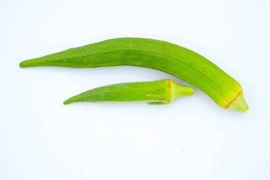 Beyaz arka planda izole edilmiş taze bamyanın yakın plan görüntüsü. Taze yeşil bamya sebzesi beyaz arka planda izole edilmiş. Beyaz arka planda bamyalar. Beyaz arka planda bamya ya da kadın parmağı sebzesi.