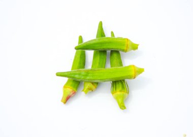 Beyaz arka planda izole edilmiş taze bamyanın yakın plan görüntüsü. Taze yeşil bamya sebzesi beyaz arka planda izole edilmiş. Beyaz arka planda bamyalar. Beyaz arka planda bamya ya da kadın parmağı sebzesi.