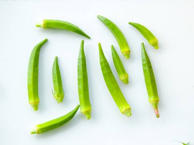 Beyaz arka planda izole edilmiş taze bamyanın yakın plan görüntüsü. Taze yeşil bamya sebzesi beyaz arka planda izole edilmiş. Beyaz arka planda bamyalar. Beyaz arka planda bamya ya da kadın parmağı sebzesi.