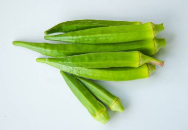 Beyaz arka planda izole edilmiş taze bamyanın yakın plan görüntüsü. Taze yeşil bamya sebzesi beyaz arka planda izole edilmiş. Beyaz arka planda bamyalar. Beyaz arka planda bamya ya da kadın parmağı sebzesi.