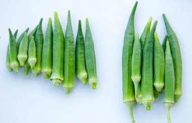 Beyaz arka planda izole edilmiş taze bamyanın yakın plan görüntüsü. Taze yeşil bamya sebzesi beyaz arka planda izole edilmiş. Beyaz arka planda bamyalar. Beyaz arka planda bamya ya da kadın parmağı sebzesi.