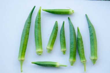 Beyaz arka planda izole edilmiş taze bamyanın yakın plan görüntüsü. Taze yeşil bamya sebzesi beyaz arka planda izole edilmiş. Beyaz arka planda bamyalar. Beyaz arka planda bamya ya da kadın parmağı sebzesi.