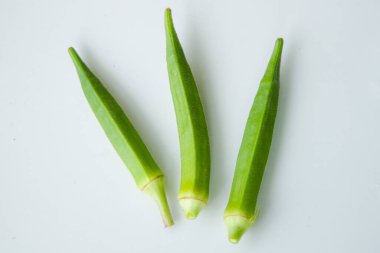 Beyaz arka planda izole edilmiş taze bamyanın yakın plan görüntüsü. Taze yeşil bamya sebzesi beyaz arka planda izole edilmiş. Beyaz arka planda bamyalar. Beyaz arka planda bamya ya da kadın parmağı sebzesi.