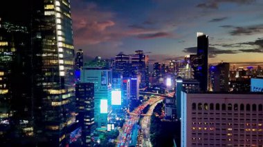 Jakarta, Endonezya, 14 Nisan 2025: Jakarta gökdelenler ve arka planda trafik ile altın saatinde gökyüzü.