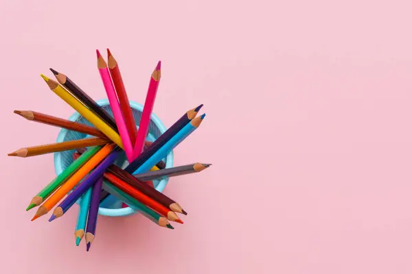 Colored wooden pencils on pink background, education concept