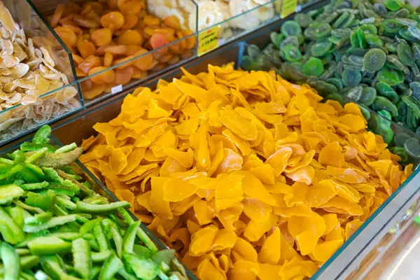 stock image A variety of dried fruits in glass containers on display in a market. Close-up shot. Concept of healthy snacking and natural food options