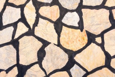 Siyah havan hatları olan düzensiz taş bir duvara yakın plan. Dış planda doğal taş dokusu. İnşaat ve mimari kavramı