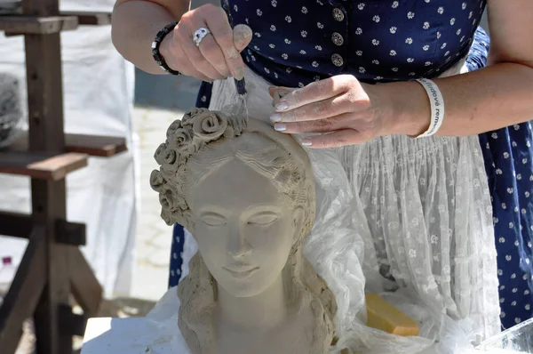 stock image A folk artist sculpts a woman's head in clay at the European Folk Crafts Fair ELRO in Kemarok, Slovakia.