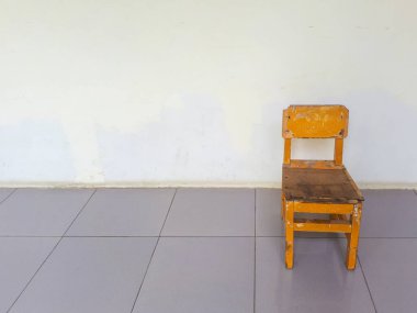 Boş alanların arasında küçük kahverengi bir sandalye.