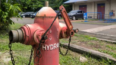 Yıpranmış itfaiye vanasına yakın çekim. Acil su erişimi için zincir ve ingiliz anahtarıyla..