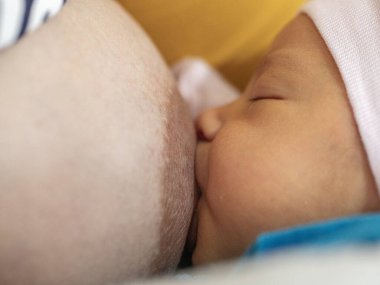Yeni doğan bebek annesinden huzur içinde emziriyor.