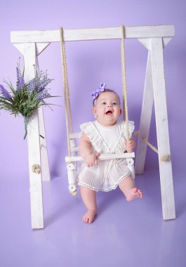 Bebek kız poz veriyor ve gülümsüyor.