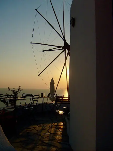 Santorini adasında yel değirmeniyle harika bir gün batımı.