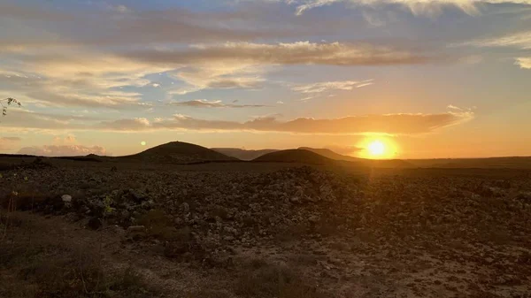 Fuerteventura 'nın kuzey kesimindeki volkanik adanın üzerinde muhteşem bir gün batımı ve ay.