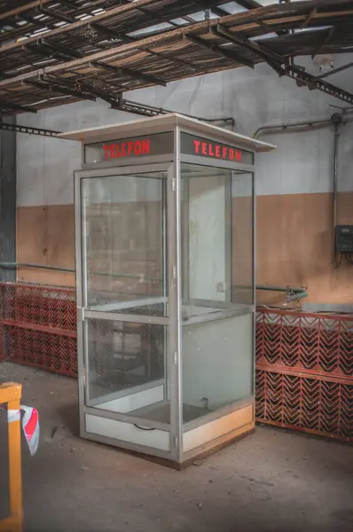 Depoda üzerinde tabela olan küçük bir telefon kulübesi.