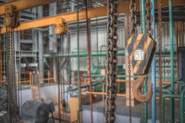 a large industrial area with a bunch of chains hanging from the ceiling