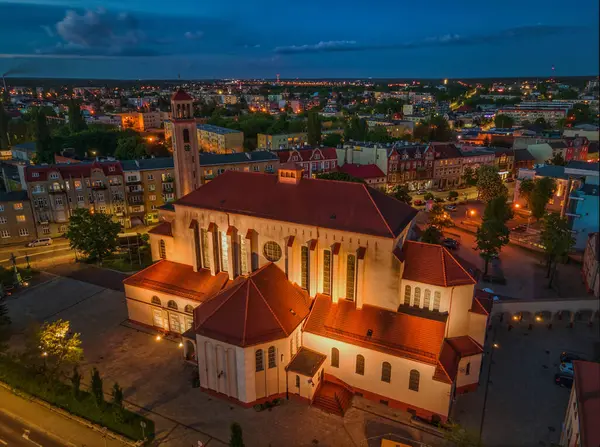 Gece büyük bir kilise, arka planda bir şehirle aydınlandı.