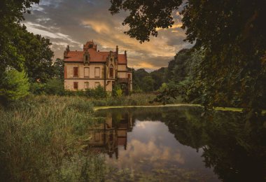 Önünde gölet olan bir ev.