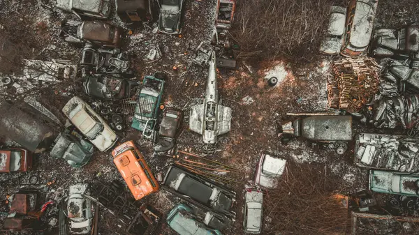 Bir tarlada bir sürü hurda araba ve kamyon var.