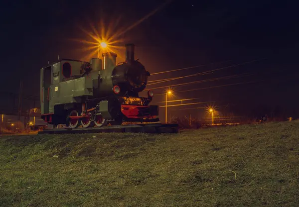Gece bir tren raylarda, ışıklar açık.