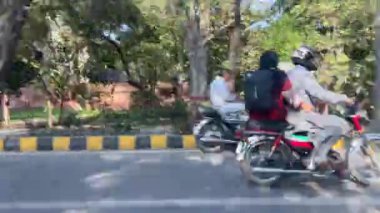 16 Mart 2024 'te Lahor Pakistan' da kişisel araba yolculuğu sırasında Kasur karayolu trafiği ve pazarı manzarası.