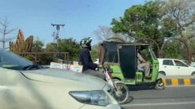 16 Mart 2024 'te Lahor Pakistan' da kişisel araba yolculuğu sırasında Kasur karayolu trafiği ve pazarı manzarası.