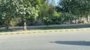 16 Mart 2024 'te Lahor Pakistan' da kişisel araba yolculuğu sırasında Kasur karayolu trafiği ve pazarı manzarası.