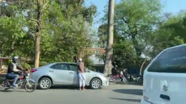 16 Mart 2024 'te Lahor Pakistan' da kişisel araba yolculuğu sırasında Kasur karayolu trafiği ve pazarı manzarası.