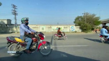 16 Mart 2024 'te Lahor Pakistan' da araba yolculuğu sırasında Ferozepur Yolu trafiği ve dükkanları dışında.