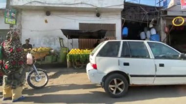 16 Mart 2024 'te Lahor Pakistan' da araba yolculuğu sırasında Ferozepur Yolu trafiği ve dükkanları dışında.