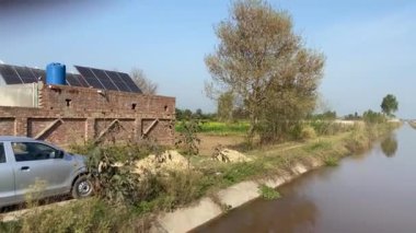 25 Mart 2024 'te Lahor Pakistan' daki tarım alanını görmek için yan yoldaki köyde seyahat etmek